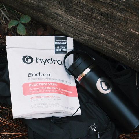 Hydra Endura electrolytes package and black water bottle on a natural background